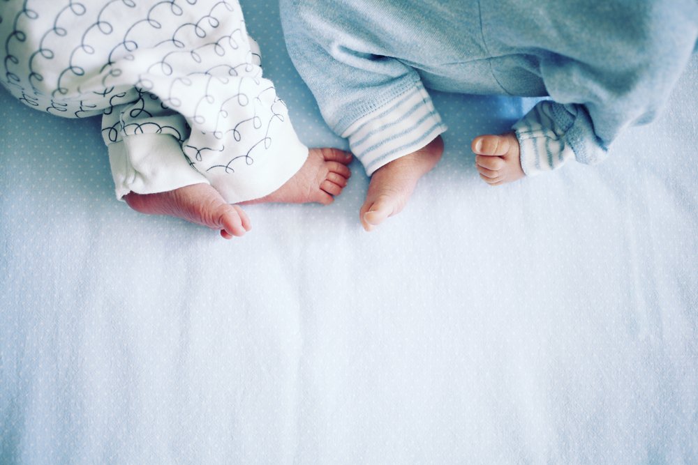 two newborn twins's feet