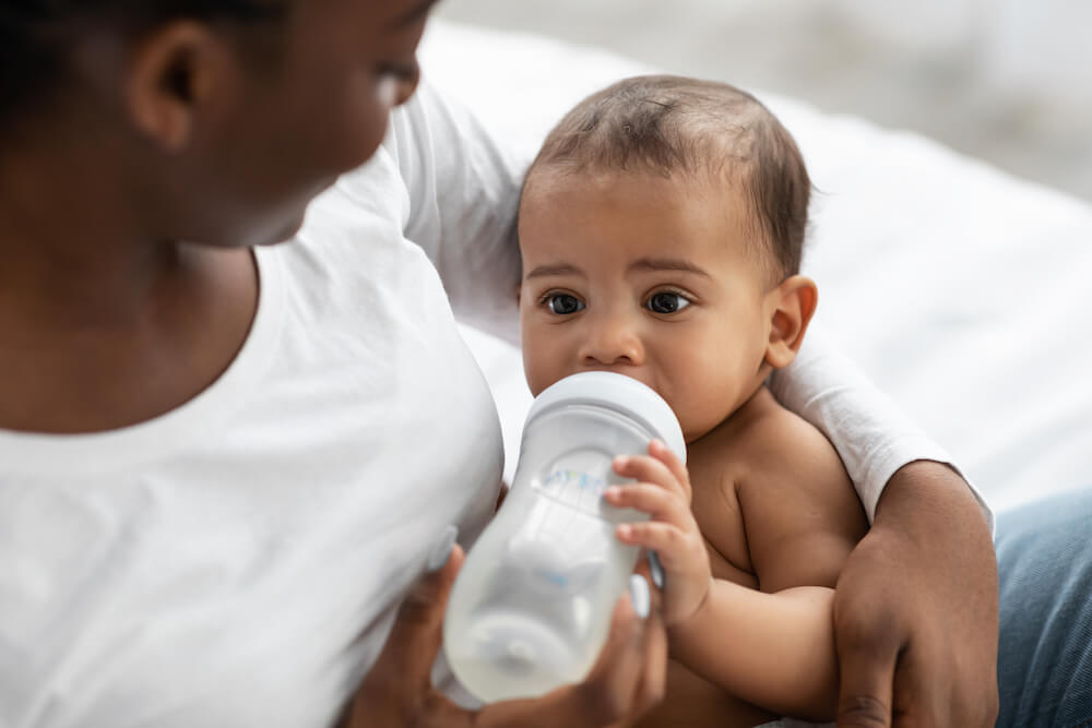when can babies hold their own bottle - baby self-feeding